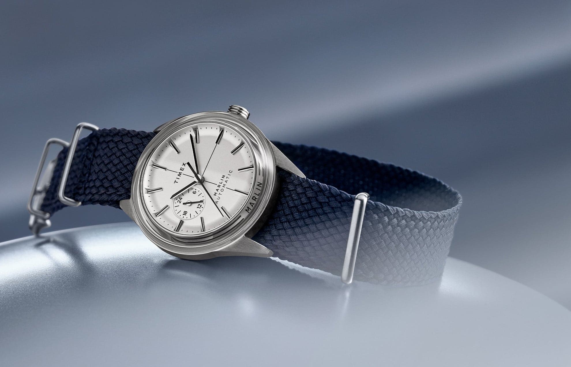 A steel Timex Marlin watch with silver dial on a blue cloth strap