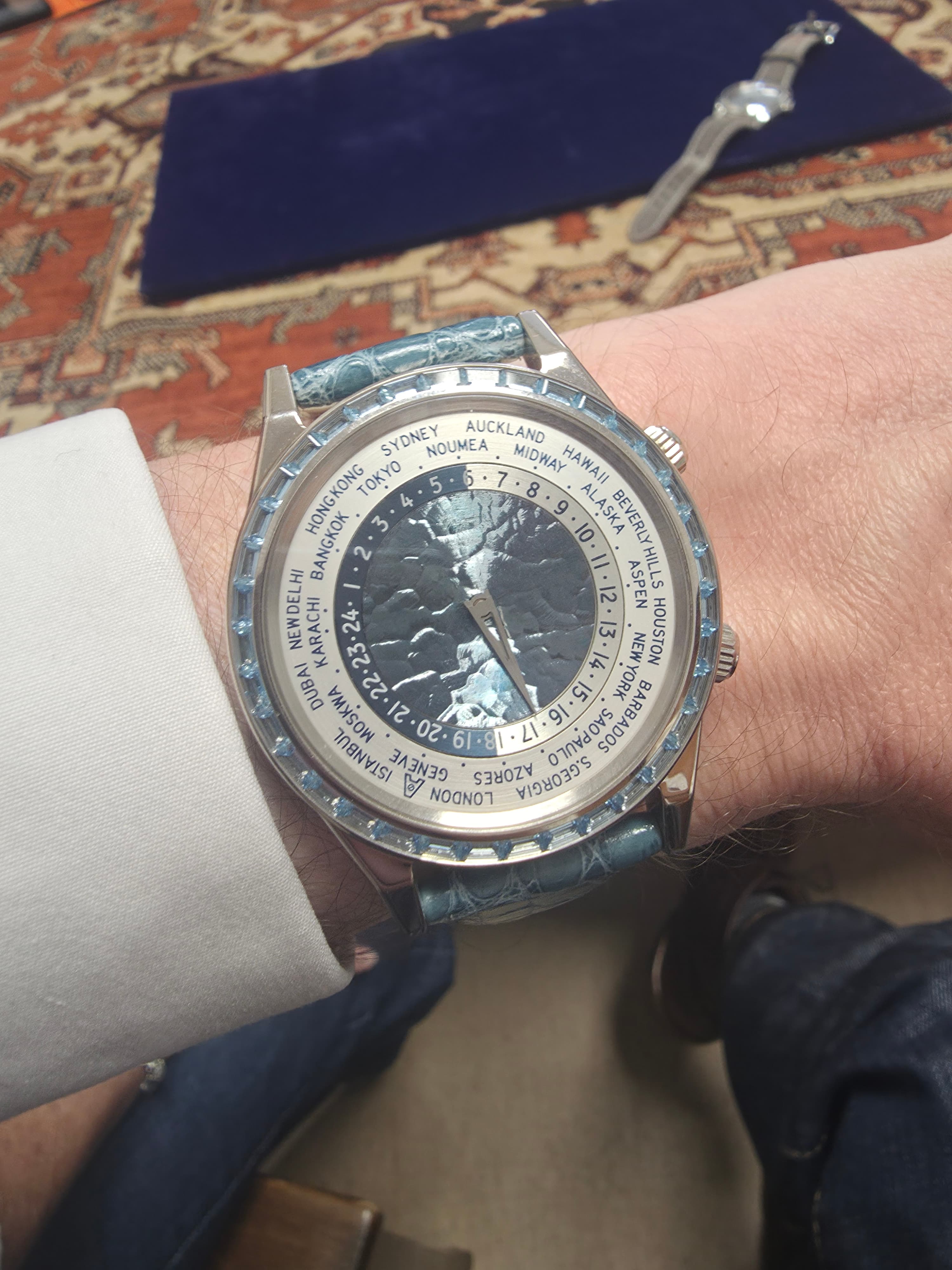 an Andersen Geneve worldtime watch with light blue gold dial centre, white dials and a ring of ultramarine gemstones on the bezel