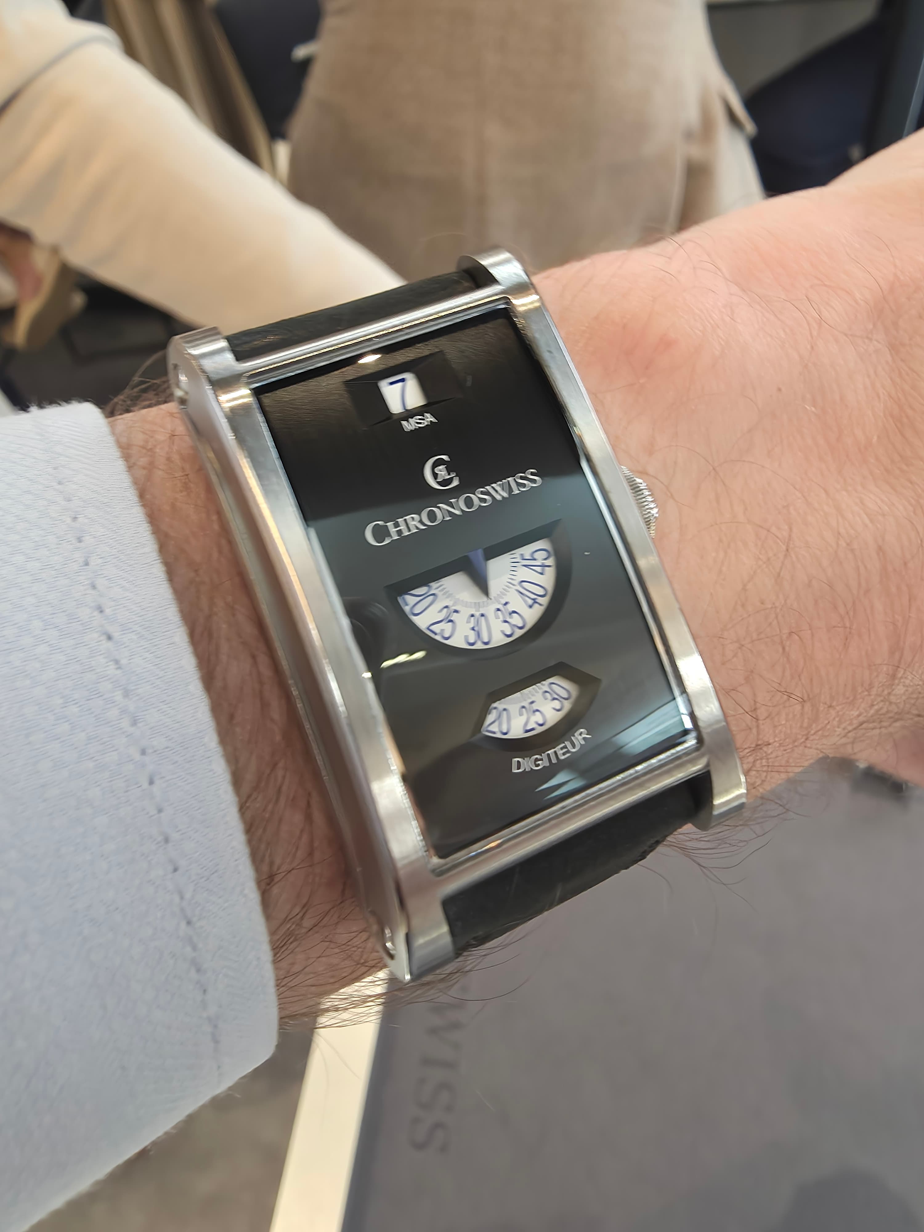 chronoswiss neo digitur in black with jump hour and rotating minutes and seconds disks and a rectangular case shape and black lacquyer dial