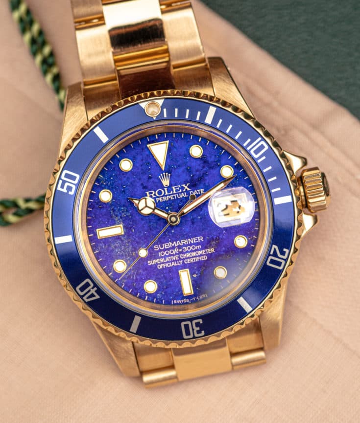 blue and gold rolex submariner with blue lapis lazulai diall and blue bezel and gold case and bracelet with shite hands and indices