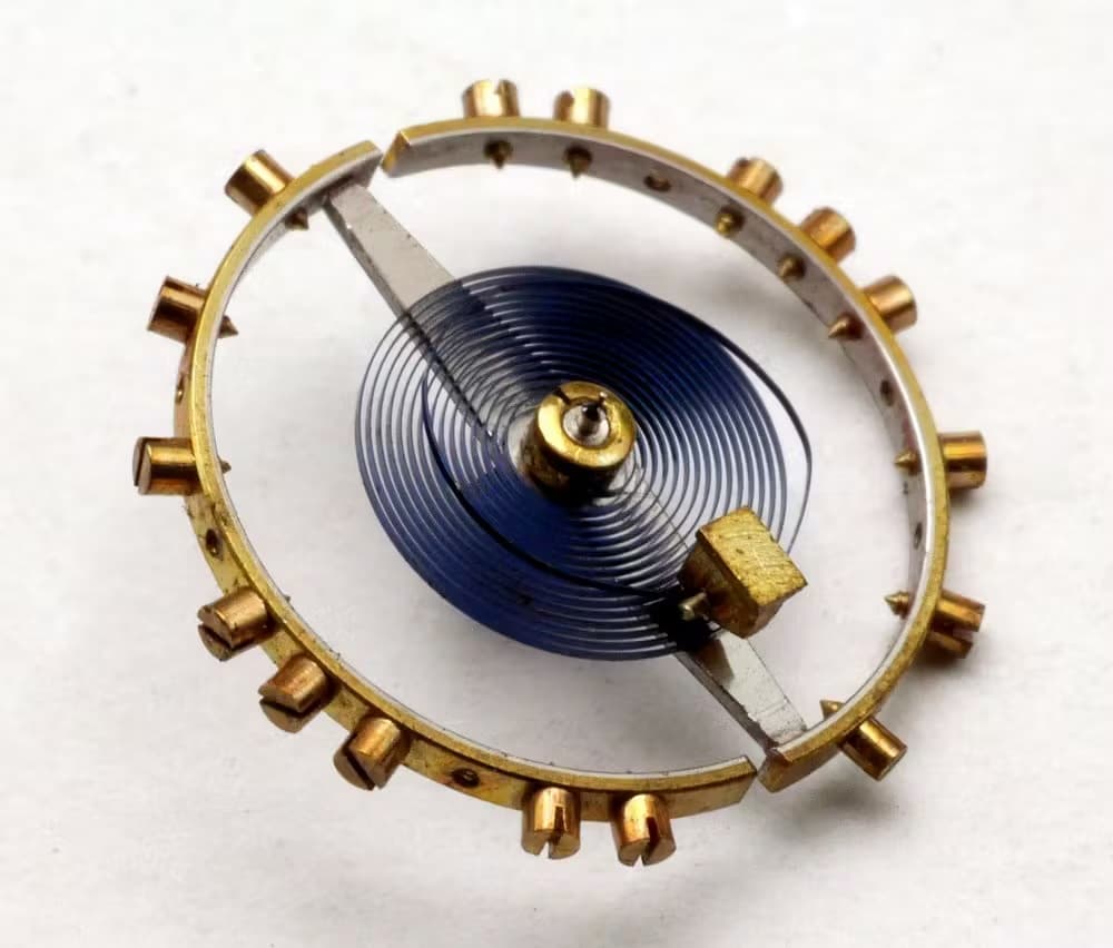 A Balance with a Balance Spring featuring an overcoil. Note the loop of the spring that is above the rest of it and of a different shape.