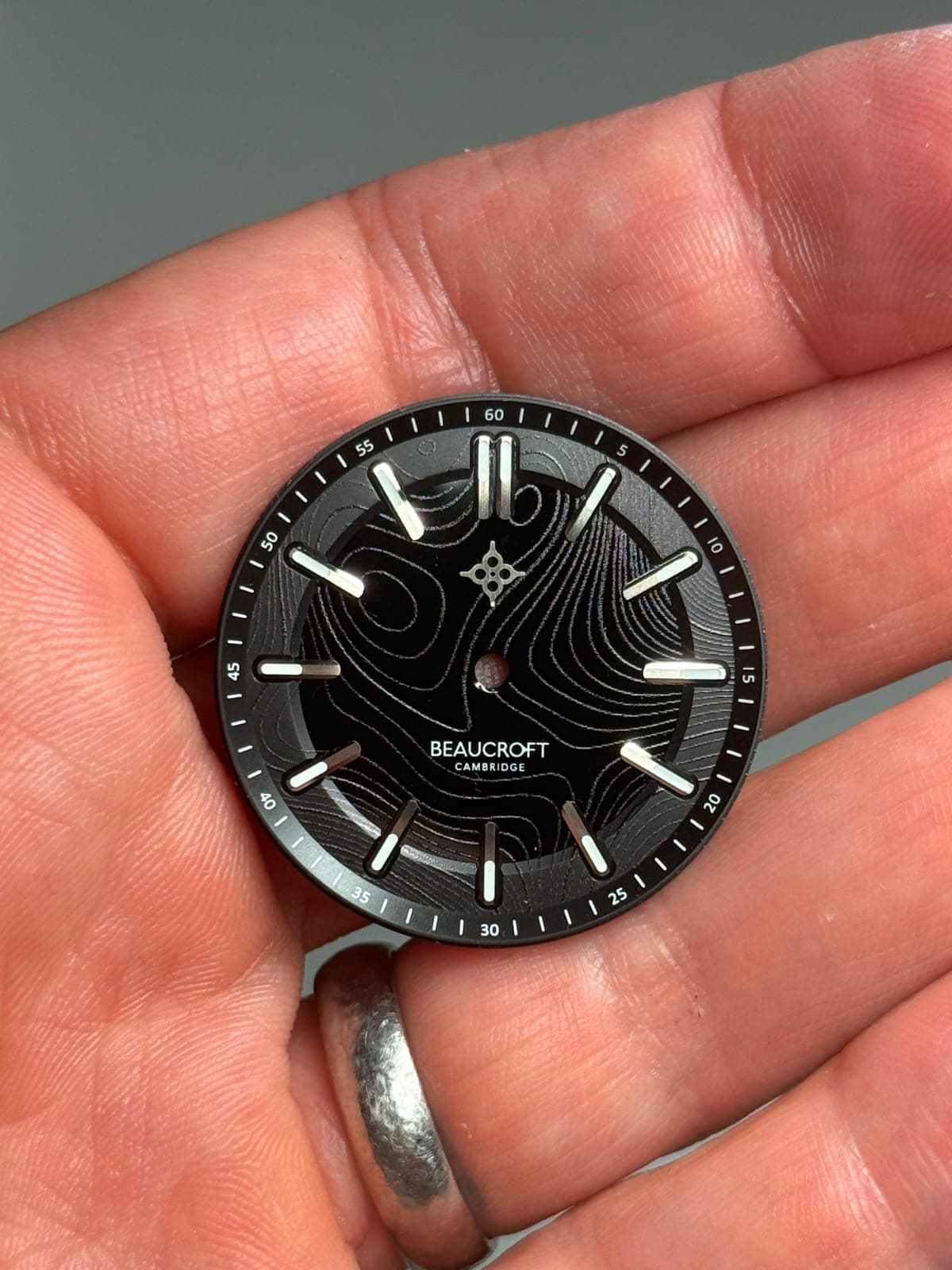a black dial with swirling lines etched into the surface